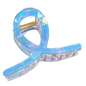 Pince à cheveux bleu clair irisé avec design croisé et ressort en métal doré pour femme
