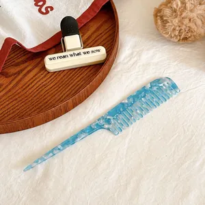 Détail du peigne en acétate de cellulose à texture marbrée bleue et blanche sur plateau