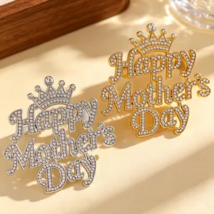 Detailed view of silver and gold Happy Mother's Day brooches with sparkling crystals