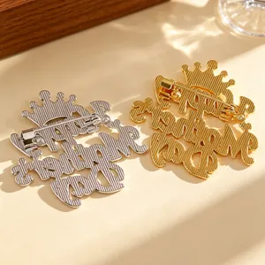 Detail of Happy Birthday Mom crown brooch in gold and silver finish with safety clasp