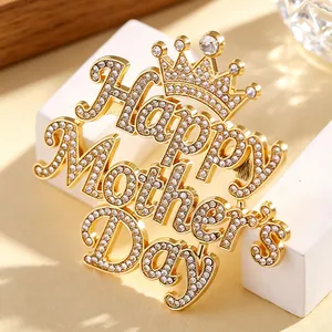 Nahaufnahme einer goldenen Muttertagsbrosche mit Strasskrone und Schriftzug