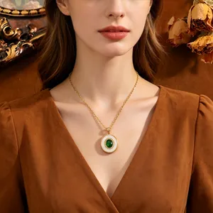 Elegante goudkleurige ketting met een groene ovale edelsteen hanger gedragen door model