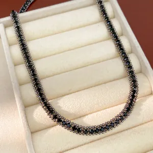 Detailaufnahme einer Halskette mit schwarzen Steinen in einer silbernen Perlenkette
