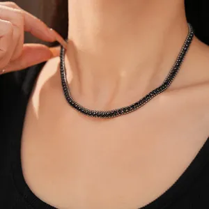 Detailansicht einer eleganten schwarzen geometrischen Strasshalskette an einem Modelhals