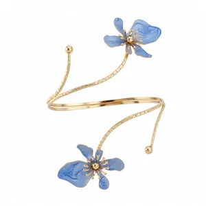 Elegante goudkleurige bovenarmband met verfijnde blauwe emaille bloemmotieven.