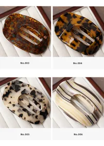 Detail showing four acetate hair clips with amber, spotted and striped patterns in a box
