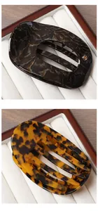 Detailed view of large acetate hair claws in dark marble and tortoiseshell patterns