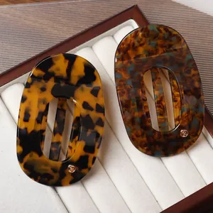 Elegant semi-circular acetate hair claw set with tortoiseshell patterns and metal logo