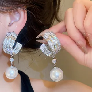 Primo piano di lussuosi orecchini in argento con zirconi e perle molto eleganti