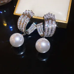 Dettaglio macro di orecchini di lusso francesi con pavé di zirconi e perle