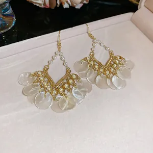 Orecchini a nappa dorati con ciondoli in conchiglia bianca e perle stile boho mare.