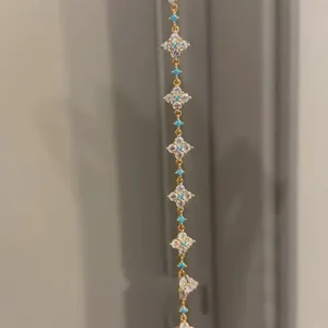 Detail view of 18k gold plated bracelet with zirconia lucky clovers and turquoise accents
