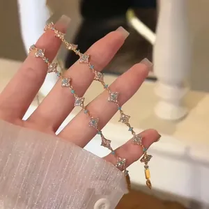 Detail view of 18k gold plated clover bracelet with sparkling zircons and blue stones