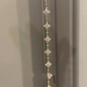 Detail view of 18k gold plated bracelet with zircon clover and turquoise beads