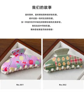 Detailed close-up of large Christmas hair claws with holiday patterns and plaid designs