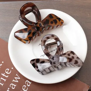 Set di due fermagli per capelli a fiocco in resina tartarugata e leopardata su vassoio