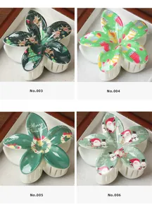 Détail de quatre pinces à cheveux fleur de Noël avec motifs Père Noël, renne et bonhomme