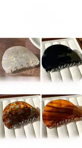 Détail de pinces à cheveux en acétate brillant en blanc, noir, ambre et motif écaille de tortue