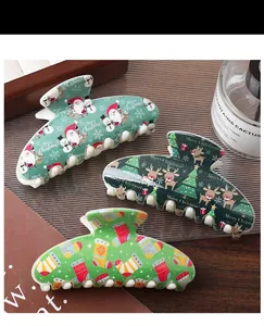 Detail of Christmas themed large hair claws with festive prints and holiday patterns