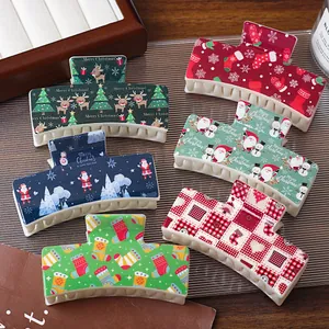Christmas themed hair claw clips set with festive cartoon patterns on a wooden surface