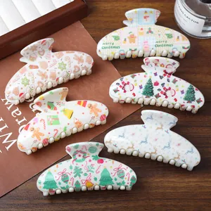 Set of 6 Christmas-themed hair claws with Santa and reindeer prints on cream plastic