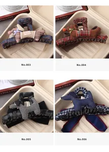 Detail view of four patterned dog-shaped hair claw clips with classic checkered fabric textures