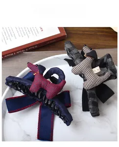 Detail of fabric puppy bow hair claw clips with plaid patterns on marble tray