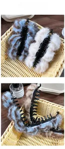 Détail de pinces à cheveux banane en peluche tigrée montrant la texture et les griffes
