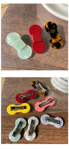 Macro detail of various colorful acetate bow hair clips with sturdy metal duckbill clips