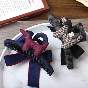 Chic puppy hair claw clips with plaid bows and padded fabric dogs on white marble tray