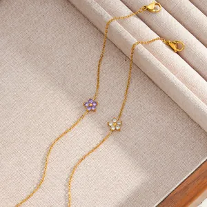 Close-up of elegant gold stainless steel flower bracelets with purple and white zircon