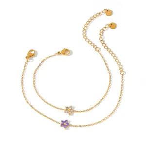 Detailed view of gold stainless steel bracelets with purple and white flower charms