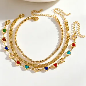 Detail of gold-tone three-piece anklet set with colorful heart charms and various chains