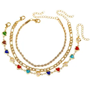 Detail shot of a three-piece bohemian gold anklet set featuring colorful heart charms