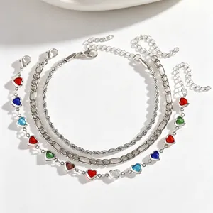 Close-up of three-piece bohemian silver anklet set with colorful heart charms.