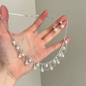 Detailansicht eines vintage Silberhalsketten- und Ohrringsets mit Strasssteinen und Perlen