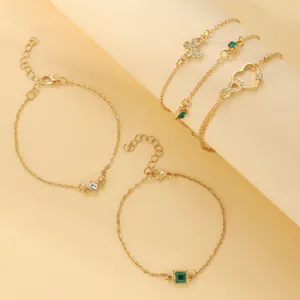 Detailed view of bohemian gold-toned anklet set with emerald green and crystal accents