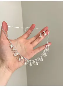 Detailansicht eines Vintage-Schmucksets aus Perlen und Strass mit Kette und Ohrringen