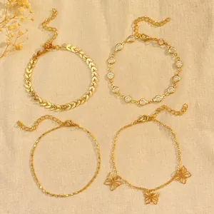 Set of four gold-finish Bohemian anklets featuring butterfly charms and crystal details