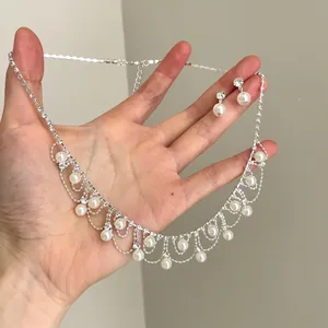 Detail eines Schmucksets mit Strass und Perlen, eleganter Halskette und Ohrsteckern