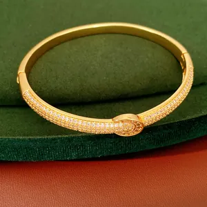Κοντινό πλάνο επιχρυσωμένου βραχιολιού 18K με ζιργκόν και κούμπωμα αγκράφας.