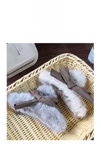 Detailed view of plush faux fur hair claws in grey and cream with brown fabric bows