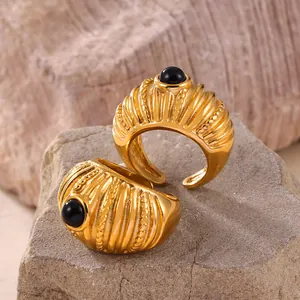 Anello vintage dorato con pietra occhio di tigre su sfondo di pietra naturale