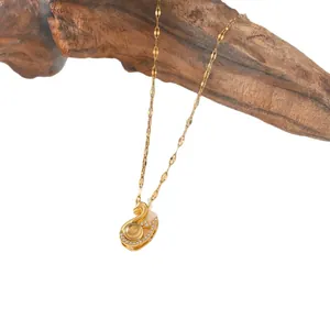 Collier de projection cygne doré élégant avec des cristaux sur un support en bois