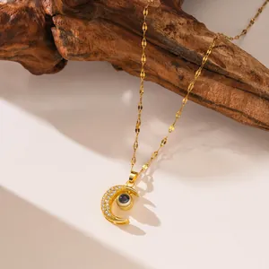 Vue détaillée du collier de projection lune dorée avec cristaux sur fond bois
