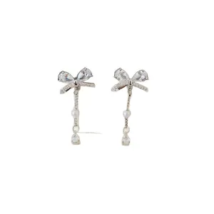 Elegant silver bow earrings featuring sparkling zircon stones and delicate white pearl tassels