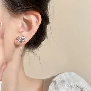 Close-up of elegant zircon bowknot tassel earrings on ear, Korean style silver jewelry