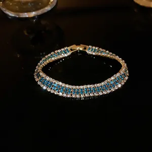 Elegantes mehrreihiges Armband mit blauen und weißen Zirkonia in Goldoptik