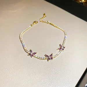 Elegant gold-tone bracelet with purple zircon butterfly charms and clear stones