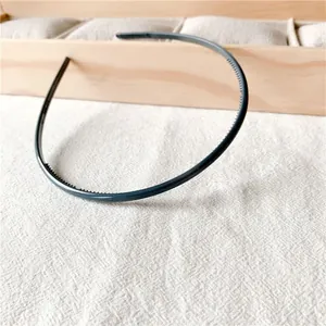 Detailed macro view of non-slip inner teeth on slim dark grey plastic headband